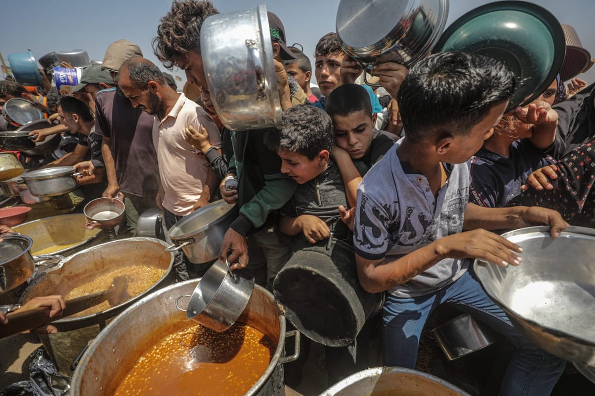 Displaced Palestinians collect donated food in Jabalia, northern Gaza